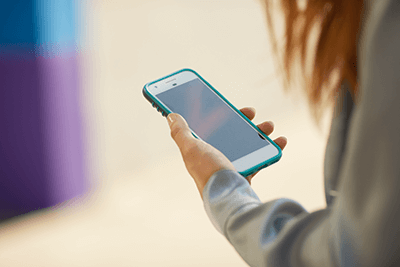 Photo of a woman using home wi-fi on her smart phone.